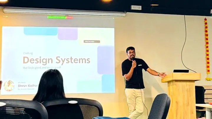 Dhruv Kothari speaking beside the projected title slide, at the meetup.